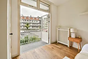 Airy Prints: Bright and inviting bedroom featuring an open door that leads to a charming balcony