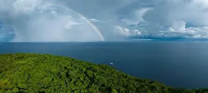 Refraction Prints: A bright rainbow appears behind a remote tropical island in the Solomon Islands