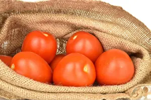 Ketchup Prints: Several bright red juicy tomatoes in a jute bag, close-up