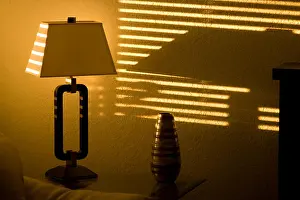 Reflecting Prints: Bright sun shining through window blinds and casting stripes on to a wall