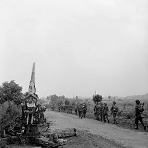 The British Army in North-west Europe 1944-45 Infantry of 50th (Northumbrian) Division moving up past a knocked-out German 88mm gun near Joe's
