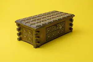 Brown closed wood jewelry box upper view isolated on yellow background