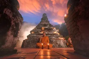 Praying Prints: Buddhist monk in traditional orange robe (kasaya) sitting on the floor of a temple meditating