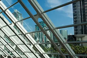Rises Prints: Buildings in downtown San Diego as seen through slanted glass wall in San Diego Convention Center