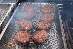 Coal Prints: Burgers cooking on a disposable barbeque in the Summer.in the UK