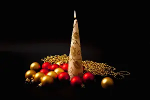 Ornaments Prints: Burning candle with christmas-tree decorations on black background