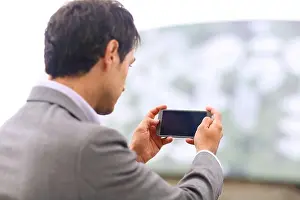 Executives Prints: Business man with smartphone in parking business center