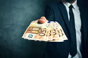 Loan Prints: Businessman from bank offering money loan in euro banknotes, selective focus