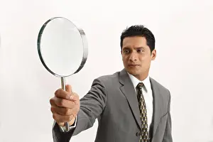 Businessman holding magnifying glass in right hand MR#703T