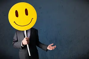 Hiding Prints: Businessman holding a smiley face emoticon