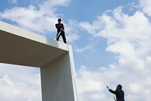 Mid Adults Prints: Businessman lends helping hand to colleague