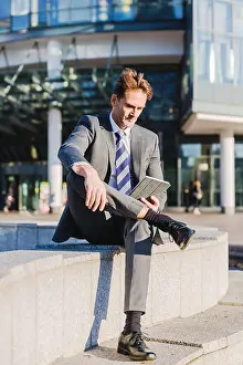 Pause Prints: businessman makes a rest in the city and works with a tablet