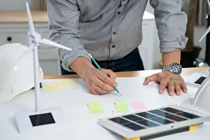 Businessmen with solar panel on desk in office