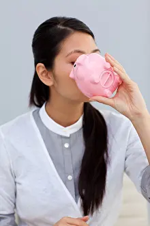 Kissing Prints: Businesswoman kissing a piggybank
