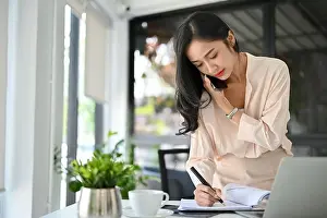 Concentrated Prints: Busy and professional millennial Asian businesswoman is on the phone with a business partner