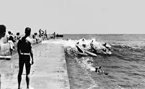 Surfers Prints: California surfers catching a wave along the Newport Harbor jetty in Corona del Mar in the early 1930s