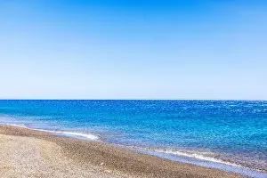 Beachside Prints: Calm Mediterranean Sea with pebble beach on Crete island, Greece, under clear blue sky