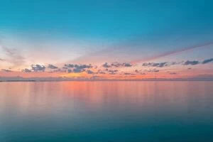 Images Dated 16th December 2018: Calm sea with sunset sky and sun through the clouds over. Meditation ocean and sky background