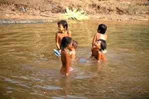 Playtime Prints: Cambodian children playing in the water at Angkor Wat temple.Siem Reap