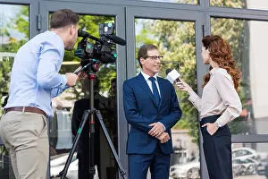 Journalist Prints: cameraman and news anchor interviewing businessman near office building