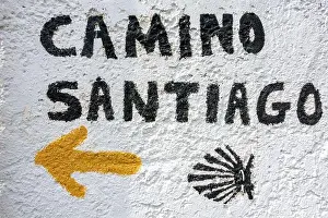 Northern Spain Prints: Camino De Santiago sign with the traditional yellow arrow and shell directing the pilgrim on the route