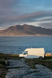 Camper van motorhome with solar panels view on a sea landscape with mountains living van life in Galiza, Spain