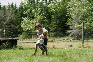Mischief Prints: Canada, Ontario, Kingston, Boys (8-9, 14-15) play fighting outdoors