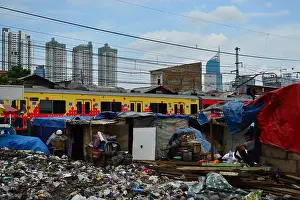 Rises Prints: Canvas used as roof of slum house with tall skyscrapers behind, Jakarta, Indonesia