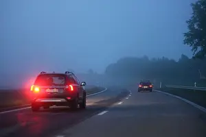 Motorway Prints: Car on a dark, foggy motorway with the fog warning light lit