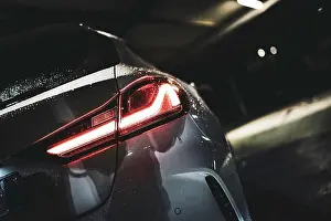 Reflecting Prints: Car taillight glowing red in a dark parking garage