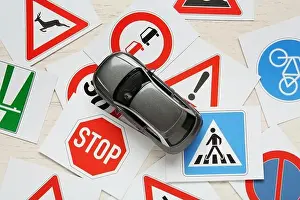 Rules Prints: Cards with different road signs and toy car on white wooden table