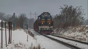Cargo train with motor engine in winter snowy morning near cold village Lenesice CZ 12 09 2023