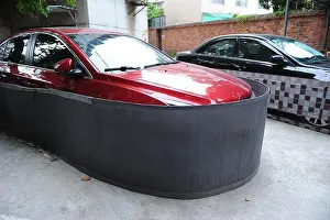 Guangxi Prints: Cars are encircled by makeshift shields to prevent rats from invasion at a residential community in Nanning city