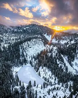 Backcountry Prints: The Cascade Range in Washington State dusted with fresh snow captured by drone with orange clouds in the sky