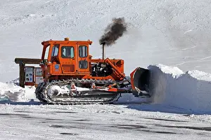 Road Construction Prints: Caterpillar bulldozer push snow off mountain road central Utah