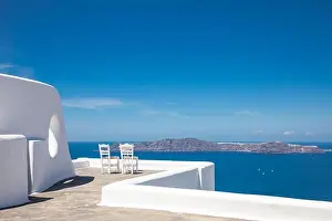 Two chairs on the terrace with sea view. White architecture on Santorini island, Greece. Travel destinations concept, summer holiday, luxury landscape