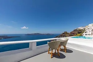 Two chairs on the terrace with sea view. White architecture on Santorini island, Greece. Travel destinations concept, summer holiday, luxury landscape