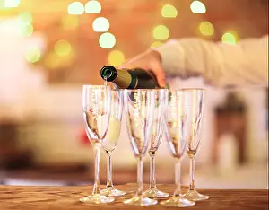 Tasting Prints: Champagne glasses on wooden table in bright lights. Party or celebration