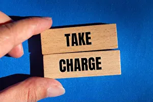 Motivate Prints: Take charge message written on wooden blocks on blue background