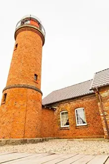 A charming brick cottage with a wooden lighthouse perched on its roof