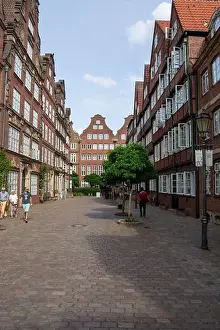 Summer Day Prints: A charming cobblestone street lined with historic brick buildings