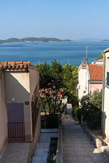 Mediterranean Lifestyle Prints: Charming Mediterranean coastal path leading down between traditional houses with terracotta roofs
