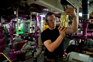 Deck Prints: Checking a fuel sample for clarity during fuel purification aboard the aircraft carrier USS John C