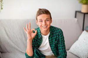 Viral Prints: Cheerful teenager guy showing okay gesture, posing on camera