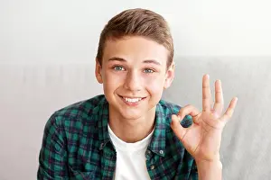 Viral Prints: Cheerful teenager guy showing okay gesture, posing on camera
