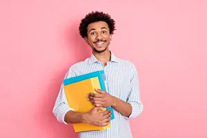 Fashion Model Prints: Cheerful Young Man Holding Colorful Folders with a Confident Smile on Trendy Pink Background