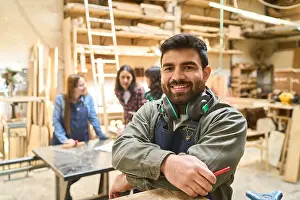 Woodwork Prints: A cheerful young worker stands confidently in a bustling lumberyard workshop