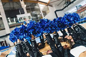 Cheerleader Prints: Cheerleaders lying on the court floor and holding shiny blue pom poms in the air