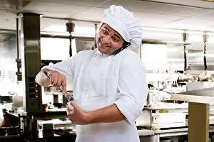 Asians Prints: Chef talking on a mobile phone while beating dough