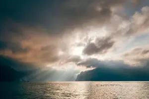 Sun Rays Prints: Cheow Lan Lake in the early morning under sunrise rays struggle through the storm clouds